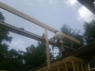 Carpenter setting a ridge beam over a new addition frame — Ice Dam Removal by Roofing Brothers in South Houston