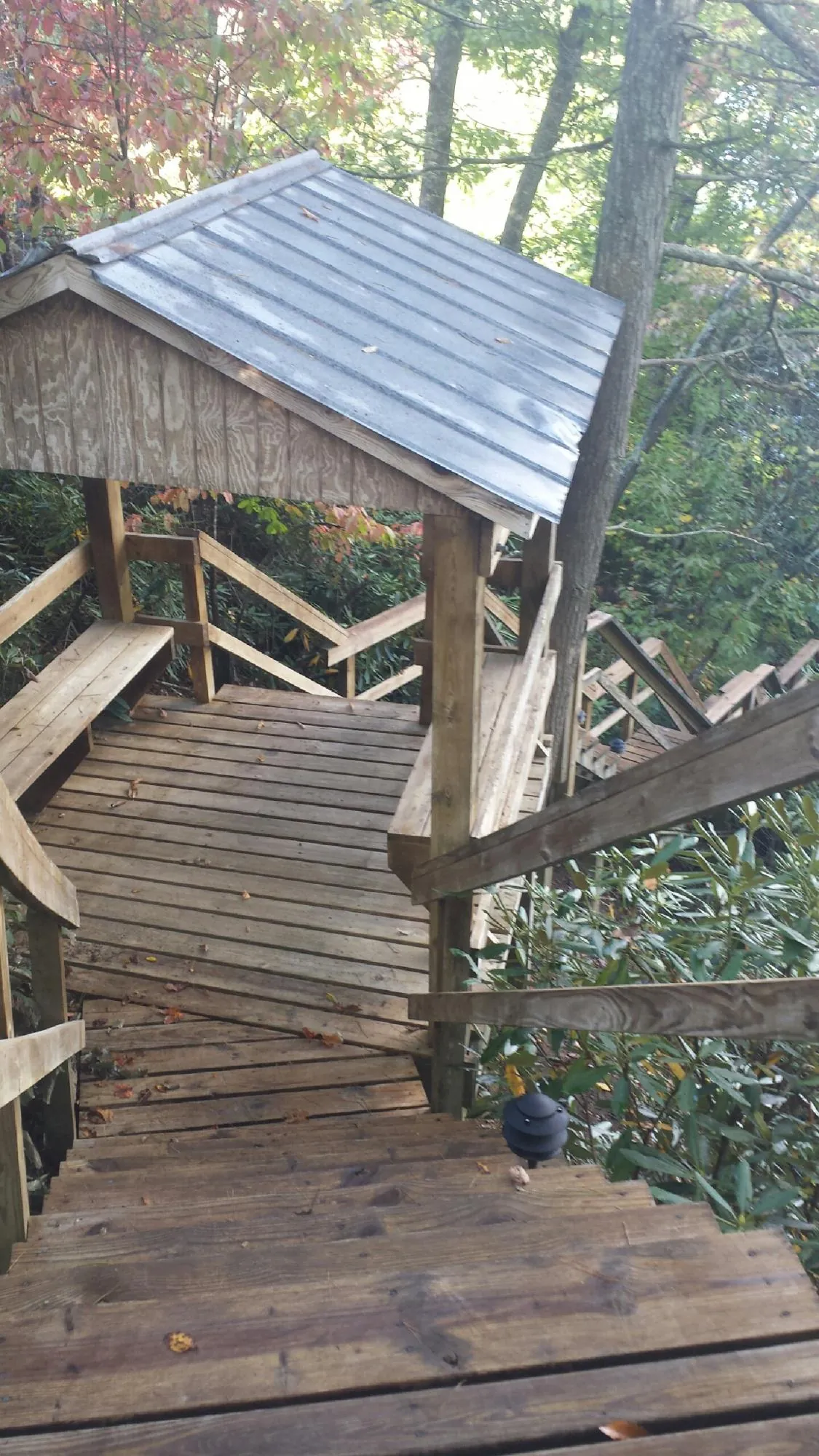 Metal roofed shelter over wooden steps on a wooded walkway — Skylight Repair & Installation work by our crew in South Houston