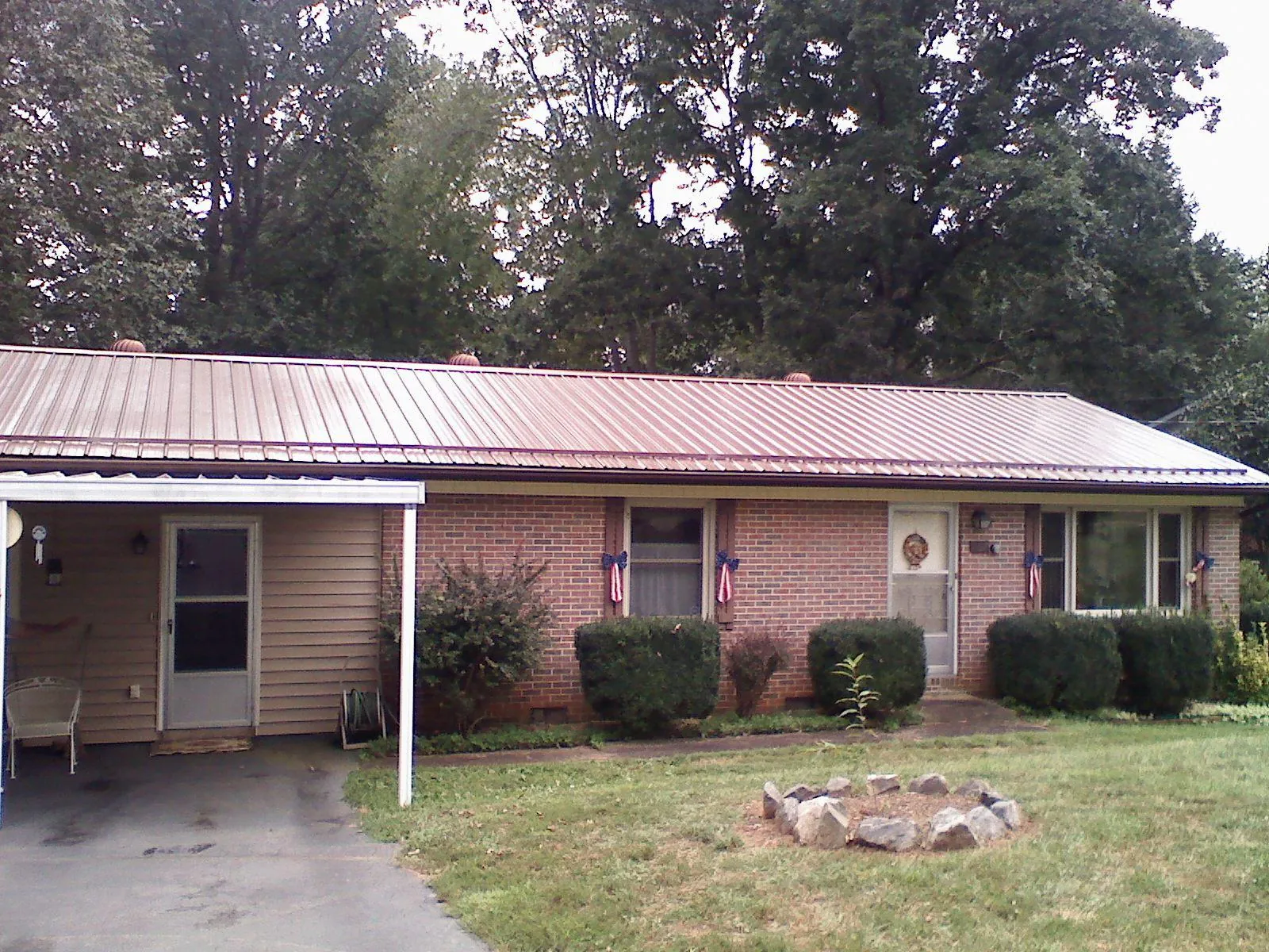 Bronze metal roof and carport on a brick ranch home — Roof Repair work by our crew in South Houston
